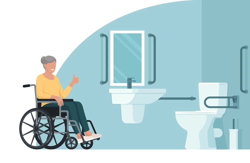 woman in wheelchair giving thumbs-up in bathroom with grab bars