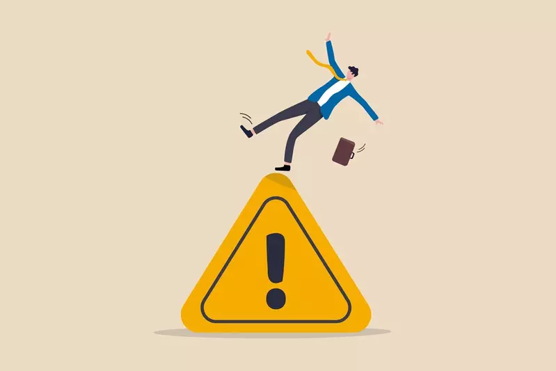 businessman tripping on caution sign to illustrate a mistake